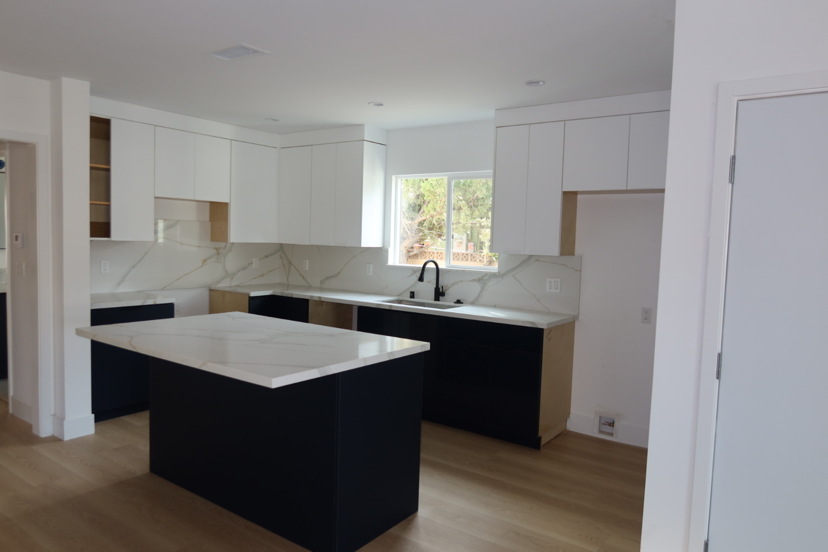 Modern kitchen with navy cabinets and marble countertops