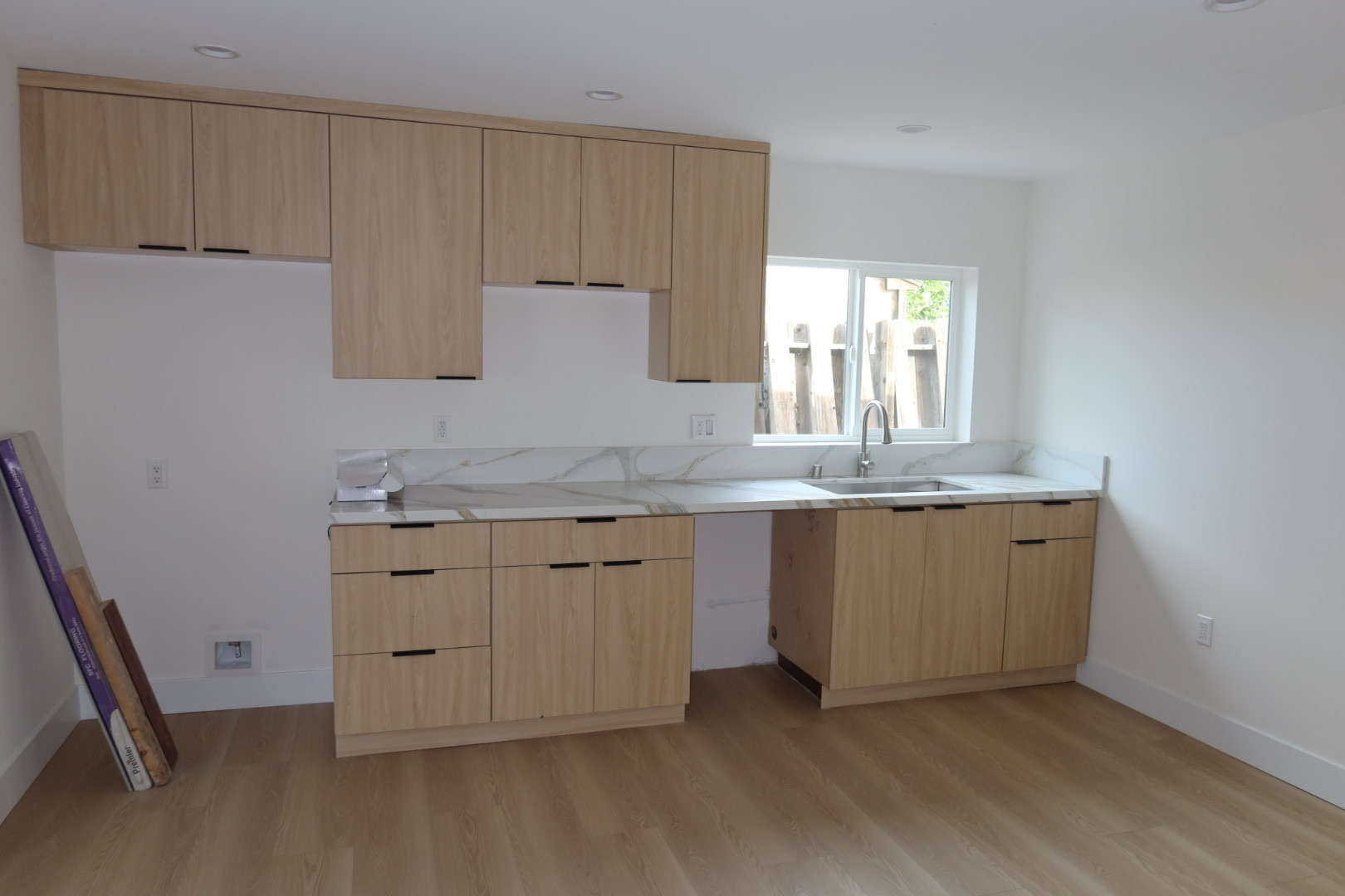 ADU kitchen with light wood cabinets